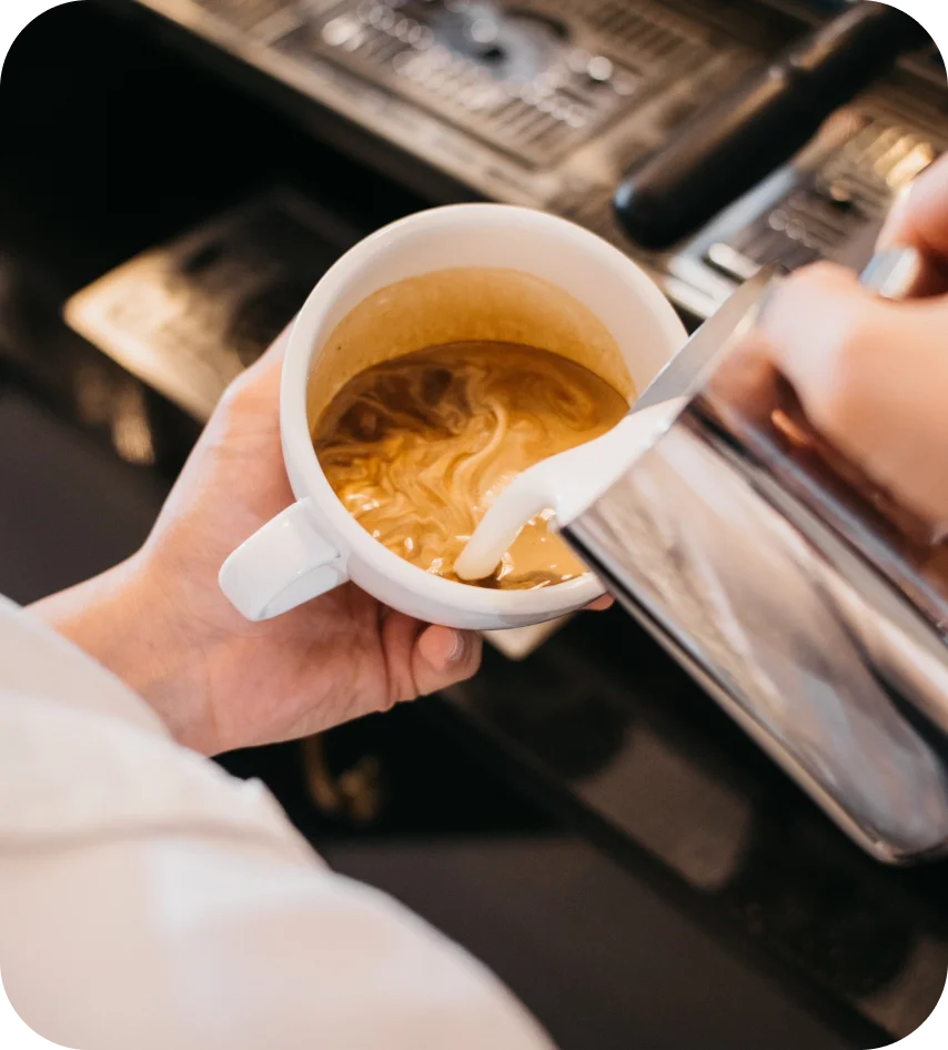 Milk being poured into a freshly brewed cup of coffee