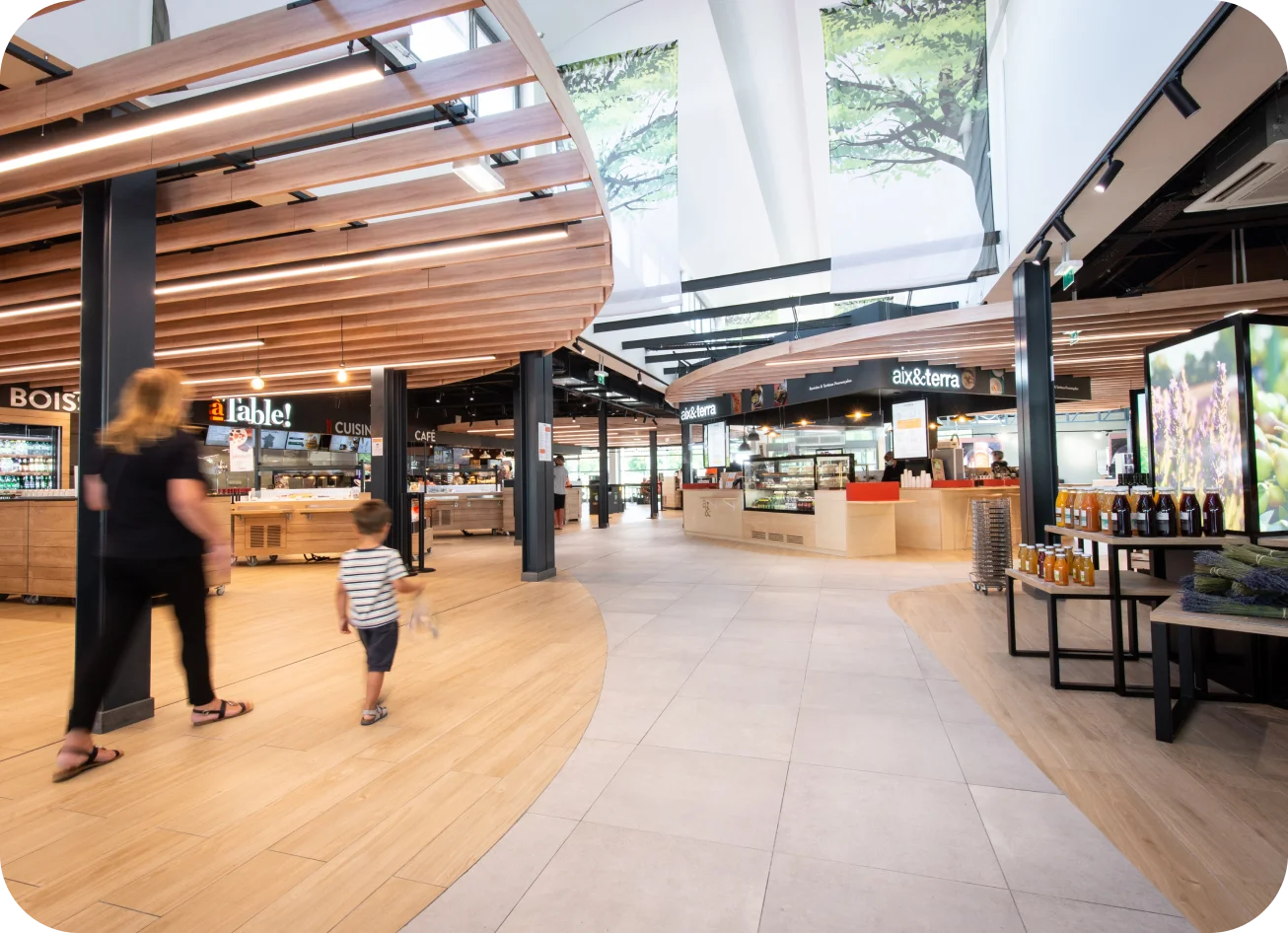 Interior of a modern food market with dining areas and people walking